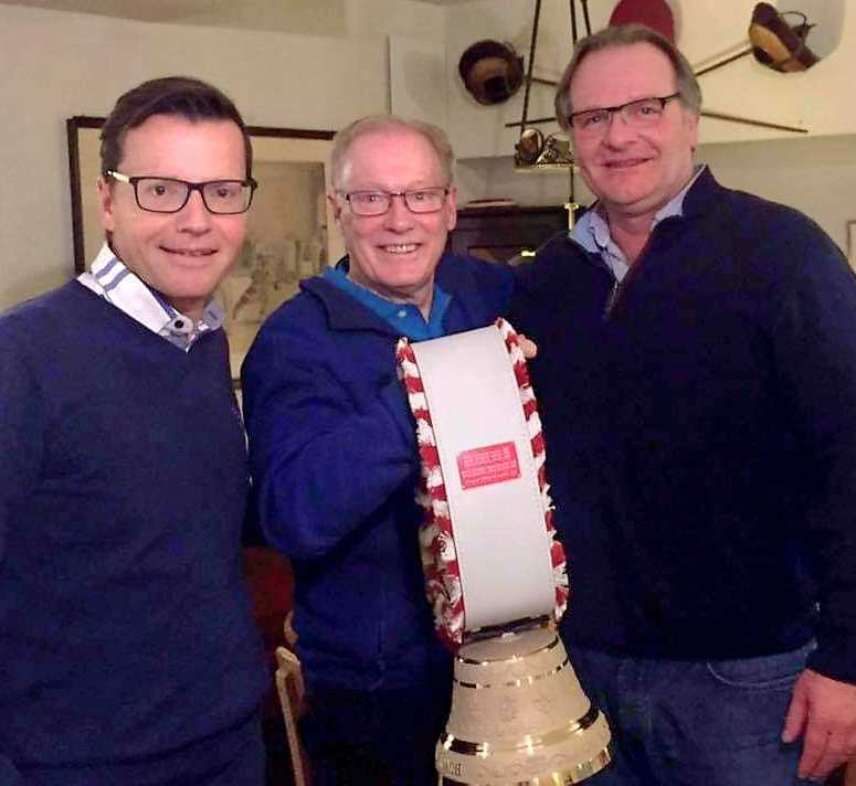 Al getting his retirement gift from two Swiss Curling representatives - a custom made cow bell.